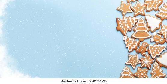 Christmas card with gingerbread cookies over blue background. Top view flat lay with space for xmas greetings