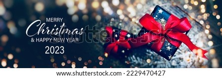 Christmas Card - Merry Christmas and Happy New Year 2023 - Beautiful gift box and golden bokeh lights