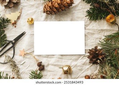 Christmas card mock up flat lay. Empty greeting card on rustic table with fir branches and pine cones. Space for text. Season's greetings. Zero waste eco postcard template. Merry Christmas - Powered by Shutterstock