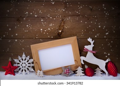 Christmas Card With Picture Frame On Snow. Copy Space For Advertisement. Red Christmas Decoration Like Christmas Ball, Snowflakes, Tree, Star And Reindeer. Wooden And Vintage Background