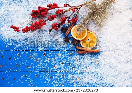 Christmas card. Spices, orange slices, Christmas tree and berries, stars, fake snow on the wooden background. Top view