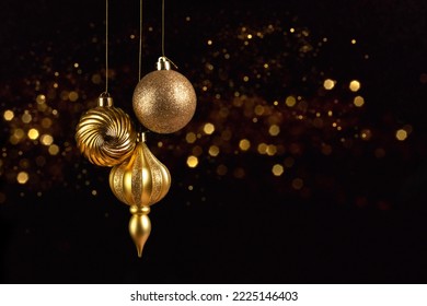 Christmas card with three golden balls decorations on black background with bokeh lights - Powered by Shutterstock