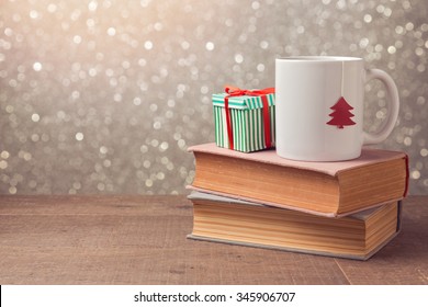Christmas celebration with cup and gift box on books over bokeh background - Powered by Shutterstock