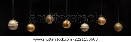 Christmas celebration holiday background banner template greeting card oanorama - Group of hanging gold golden Christmas balls Christmas baubles, isolated on black background.