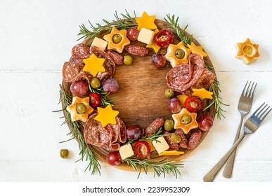 Christmas charcuterie board made in wreath shape on wooden cutting board and white wooden table  - Powered by Shutterstock