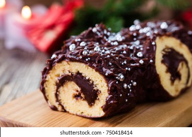Christmas chocolate log, Buche de Noel, festive holiday cake on rustic table background 