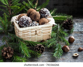 Christmas Chocolate Truffles In A Wicker Box The Fir Tree Branches On Wooden Table.