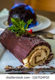 Christmas Chocolate Yule Log And Pudding On Fire With Slice Taken Out Of It 