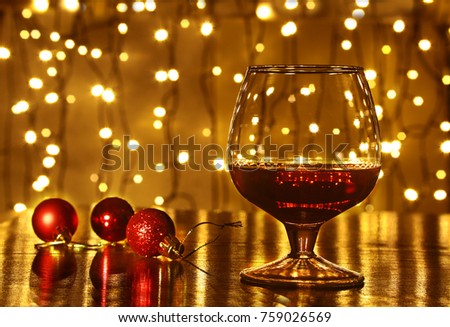 Christmas colorful balls and glass cognac or whiskey with defocused lights