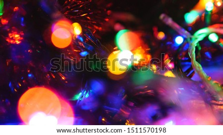 Christmas colorful New Year's Bokeh neon lights. Abstract Blurred photo background with blinking lights from tangled garlands. Decoration with bright colored neon pink blue red green flickering lights