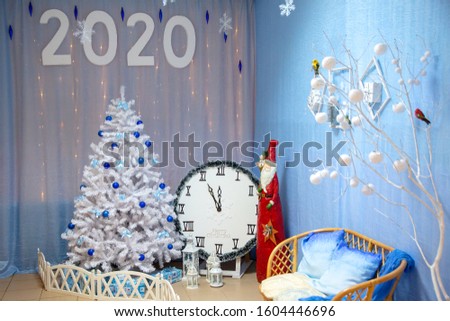 Christmas composition with an artificial Christmas tree, a figure of Santa Claus and a clock