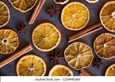 Christmas composition : Beautiful  top view flat lay arrangement of dry Oranges  cinnamon sticks and star anise on dark grey background. Rustic, Mediterranean, Holiday spices ingredients /objects
