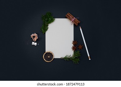 Christmas composition. Blank white card. copy space. Orange slice, star anise, christmas tree branch, cinnamon sticks, pen and paper. Black background. Top view. Flat lay. - Powered by Shutterstock