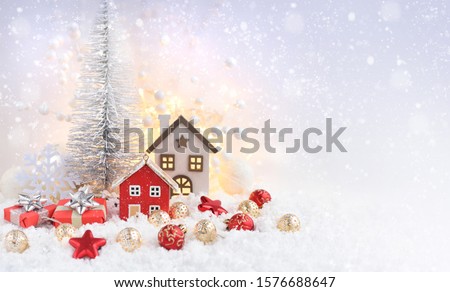 Christmas composition with decorative huts, gifts and festive decorations оn the snow. Christmas or New Year greeting card. Space for your text