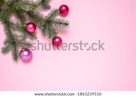 Christmas composition of fir tree branches and pink balls on pastel pink background with copy space for text. Christmas and New Year concept. 