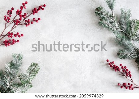 Christmas composition. Fir tree branches, red berries on gray background. Christmas, winter, new year concept. Flat lay, top view, copy space