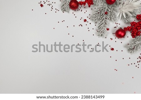 Christmas composition, fir tree branches, red berries, baubles and stars confetti on white background. Christmas, New Year, winter concept. Top view, flat lay, copy space. 