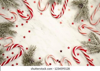 Christmas composition with frame of fir branches and candy. Flat lay, top view