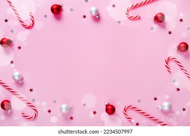 Christmas composition. Frame made of candy canes, holiday decorations on a pink background. - Powered by Shutterstock