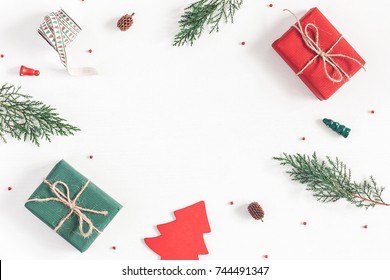 Christmas composition. Frame made of christmas gifts, pine branches, toys on white background. Flat lay, top view, copy space.