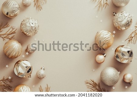 Christmas composition. Frame made of golden balls decorations on pastel beige background. Christmas, winter, new year concept. Flat lay, top view