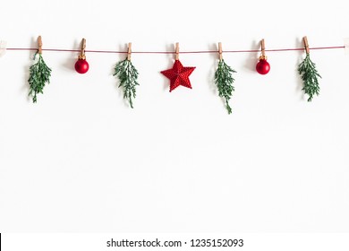 Christmas composition. Garland made of red balls and fir tree branches on white background. Christmas, winter, new year concept. Flat lay, top view, copy space - Shutterstock ID 1235152093