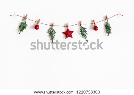 Christmas composition. Garland made of red balls and fir tree branches on white background. Christmas, winter, new year concept. Flat lay, top view, copy space