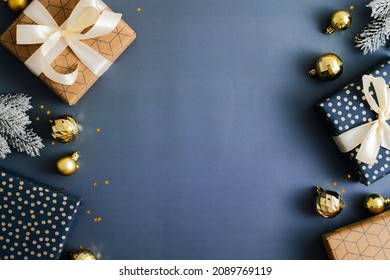 Christmas composition with gift boxes, fir branches, gold baubles on dark blue background. Top view, Flat lay. Xmas banner mockup, vintage postcard template - Powered by Shutterstock