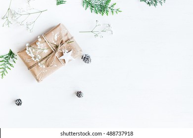 Christmas composition. Christmas gift, pine cones, thuja branches and gypsophila flowers. Flat lay, top view, copy space