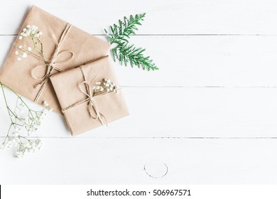 Christmas Composition. Christmas Gift, Thuja Branches And Gypsophila Flowers On White Wooden Background. Top View, Flat Lay, Copy Space