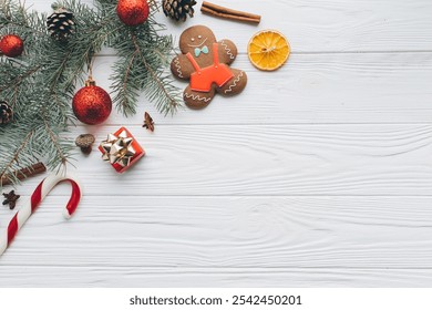 Christmas composition. Gifts, pine cones, fir branches, candy, gingerbread man, spices and other decorations on wooden white background. Flat lay, top view. - Powered by Shutterstock