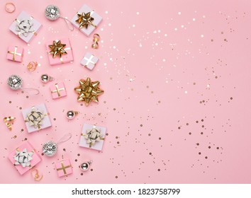 Christmas composition. Gold and silver decorations, mirror disco balls, gifts on pastel pink paper background. Christmas, winter, new year concept. Flat lay, top view, copy space.