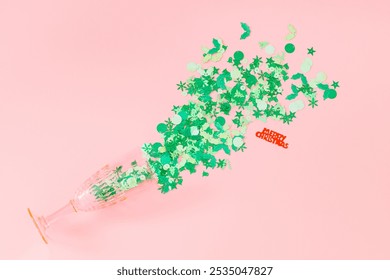 Christmas composition with green and red mix glitter confetti and pink champagne glass on pastel pink background. Festive holiday pastel backdrop. Minimal Xmas and New Year party concept. Flat lay. - Powered by Shutterstock