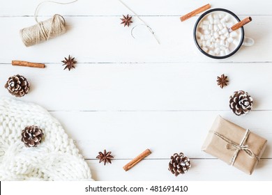 Christmas Composition. Hot Chocolate, Cinnamon Sticks, Anise Star, Marshmallow, Knitted Blanket, Gift And Cones On Wooden White Background. Winter, Christmas Concept. Flat Lay, Top View