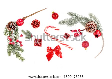 Christmas composition Isolated. Christmas  pine branches with red berries, balls, gifts and sweet cane on white background. Creative layout. Flat lay, Top view.