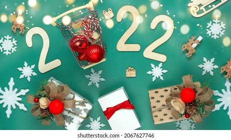 Christmas composition made of Christmas decoration and 2022 numbers on Green background  with defocused lights. Minimal concept of Xmas and New Year