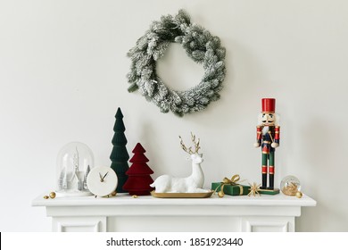 Christmas composition on the white chimney at the living room interior with beautiful decoration. Christmas tree and wreath, candles, stars, light. Copy space. Template.
