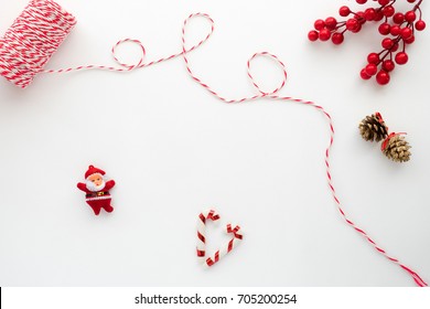 Christmas Composition. Christmas Ribbon, Holly Berry, Candy Cane, Santa Claus, And Pine Cone. Creative Flat Lay, Top View Design
