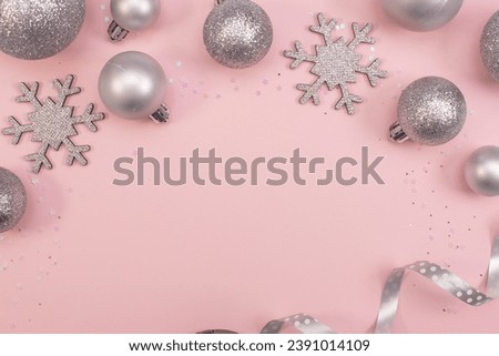 Christmas composition christmas silver tree toys ,silver snowflakes and christmasdecoration at the pink background,copy space,top view photo.