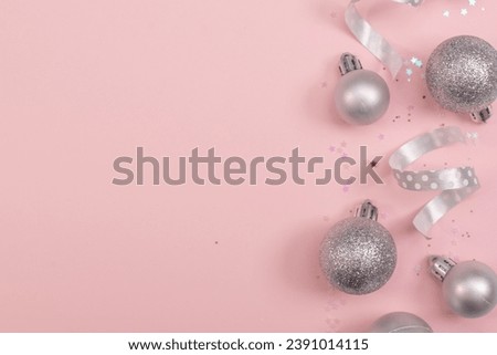 Christmas composition christmas silver tree toys ,silver snowflakes and christmasdecoration at the pink background,copy space,top view photo.