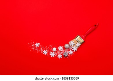 Christmas compositions.Creative layout made of white snowflakes, snow, Christmas tree and gift paint brush on red background. Flat lay, top view, copy space.
