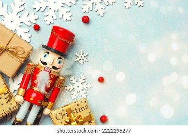 Christmas concept background. Top view of Christmas ornament and christmas wooden nutcracker toy solider with space for text over a blue background