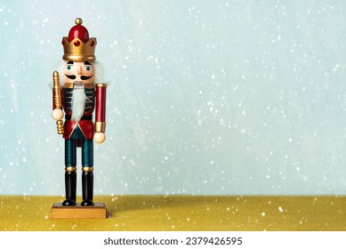 Christmas concept background. Christmas wooden nutcracker toy solider and snowflakes with space for text over blue background