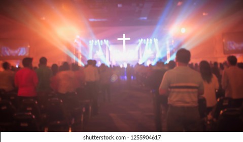 Christmas concept: Blurred Christian Congregation Worship God together in Church hall in front of music stage and light effected