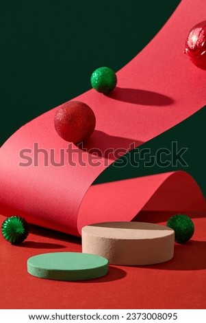 Christmas concept with green and red baubles displayed with two round-shaped podiums. Christmas is annually celebrated with various exciting welcoming activities