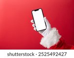 Christmas concept, Santa Claus hand holding a smartphone with blank screen with copy space on red background