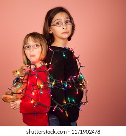 Christmas Concept shot of two little girls wrapped up in christmas lights