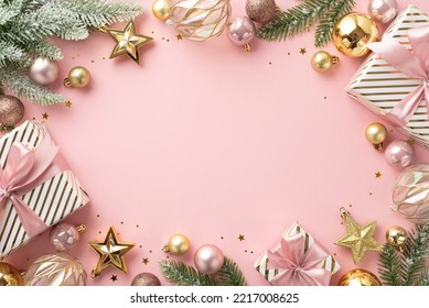 Christmas concept. Top view photo of present boxes fir branches in snow decorated with stylish baubles star ornaments and confetti on isolated light pink background with blank space in the middle - Powered by Shutterstock