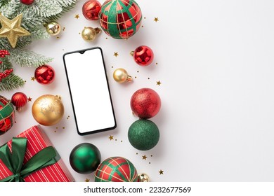 Christmas concept. Top view photo of smartphone red green and gold baubles star ornament giftbox pine branch in frost and shiny confetti on isolated white background with copyspace - Powered by Shutterstock