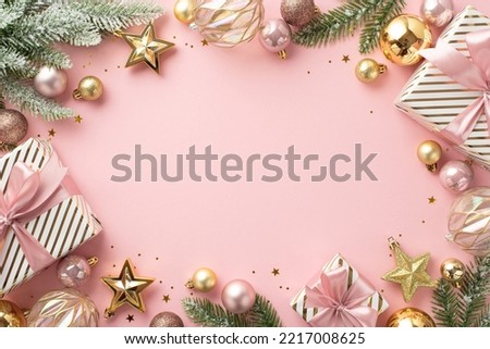 Christmas concept. Top view photo of present boxes fir branches in snow decorated with stylish baubles star ornaments and confetti on isolated light pink background with blank space in the middle